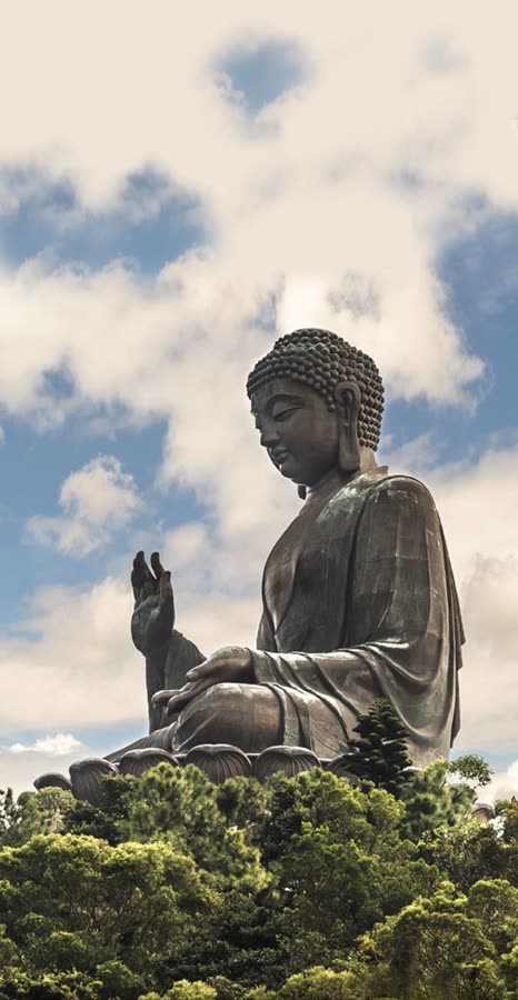 The source photo: a large bronze Buddha statue against a cloudy blue sky, above a line of trees.